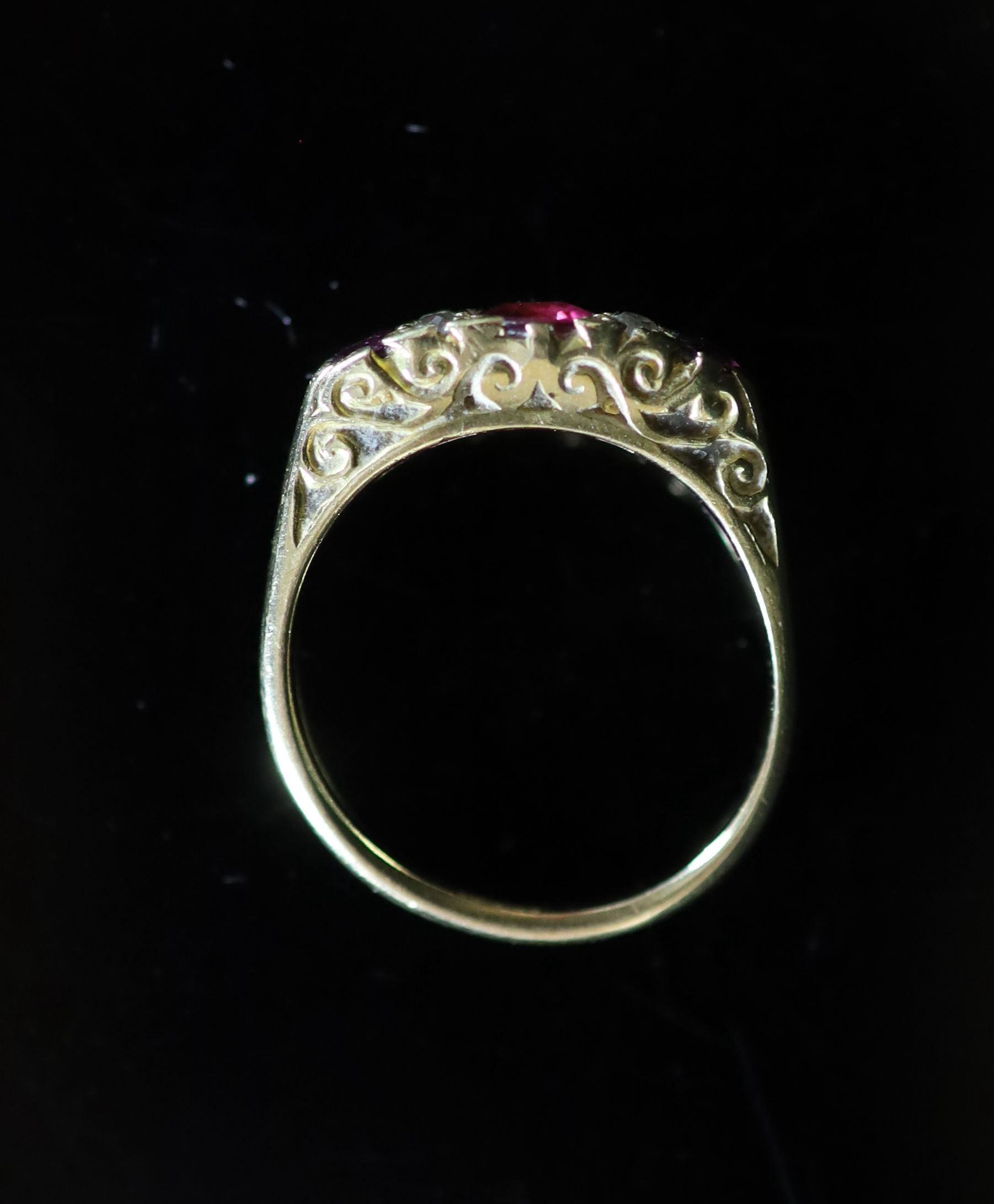 An early 20th century 18ct gold, three stone ruby and four stone diamond chip set half hoop ring